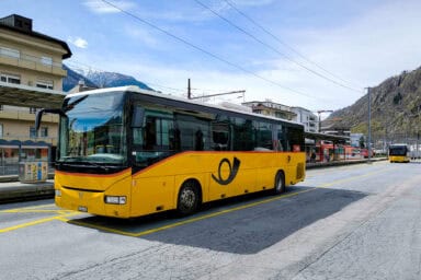 A Swiss postbus on the square of the Brig train station.