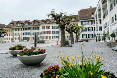 The town square of Unterseen with flowers and old buildings.