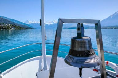 Bell on the prow of a Lake Thun boat, with Eiger and Mönch in the distance.