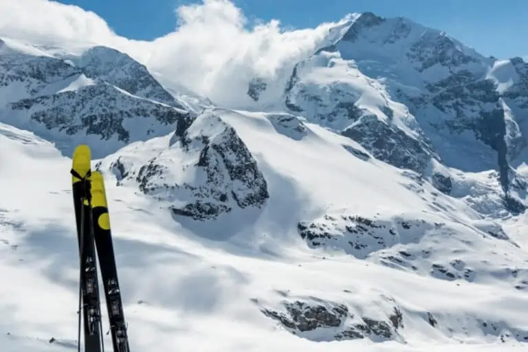 Skis in front of snow-capped Bernina mountains