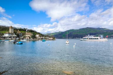 The harbor and castle of Spiez with an arriving passenger boat.