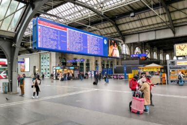 Großes Display mit Abfahrtszeiten und Gleisen in der Haupthalle des Bahnhofs Zürich HB.